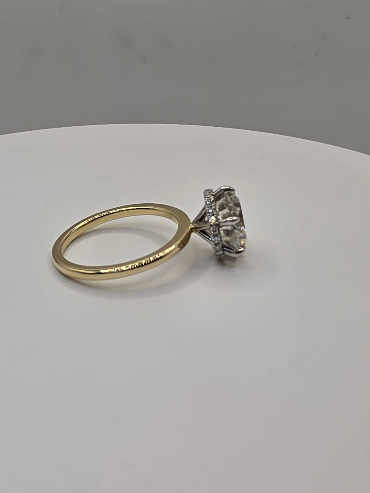 Round diamond ring with yellow gold on a white background