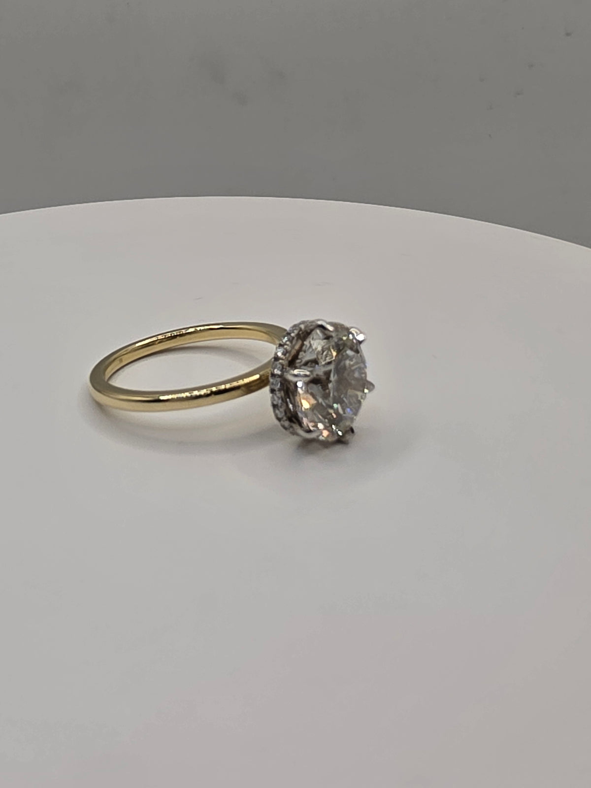 Round diamond ring with yellow gold on a white background