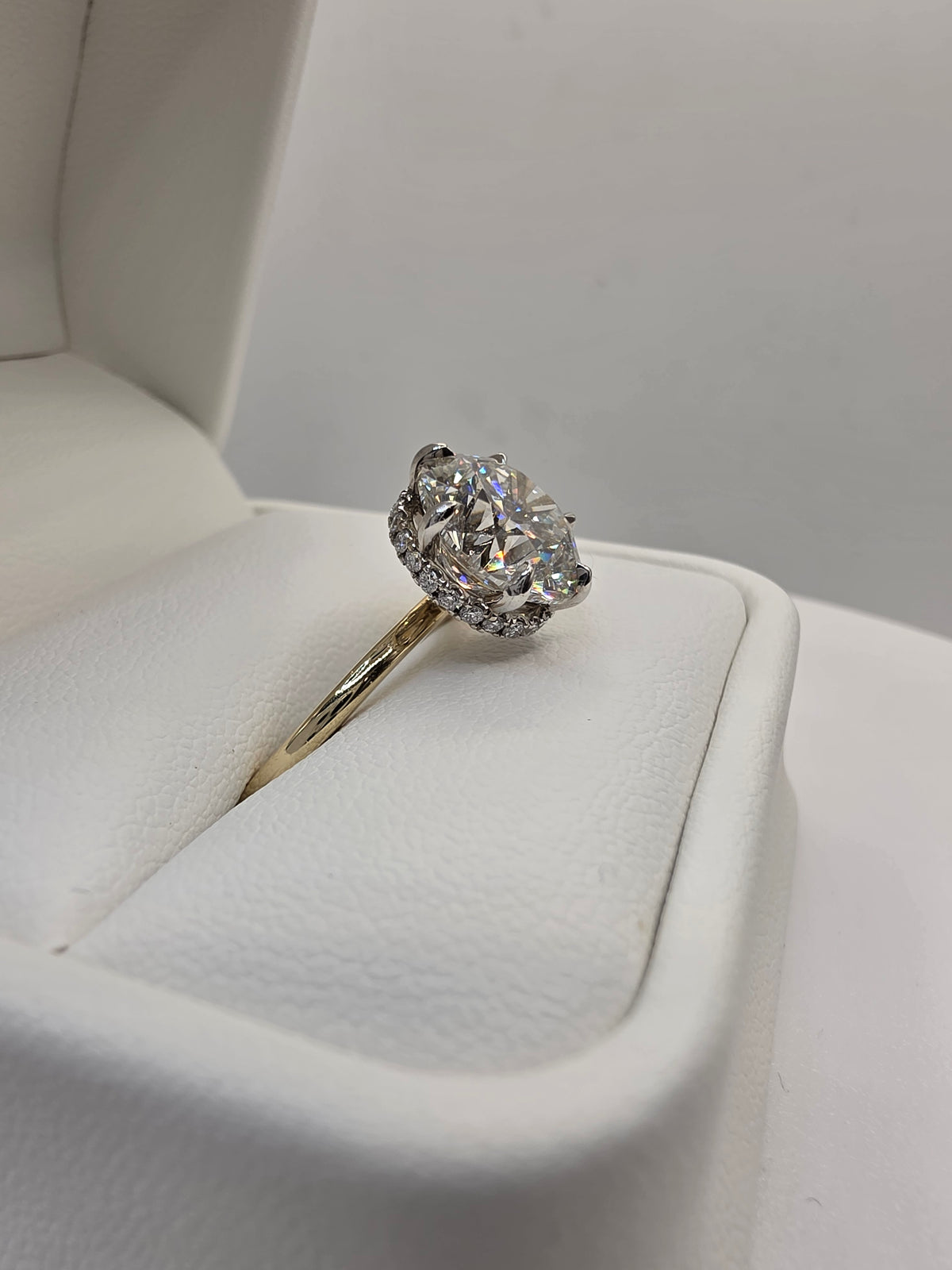 Round diamond ring with yellow gold on a white background