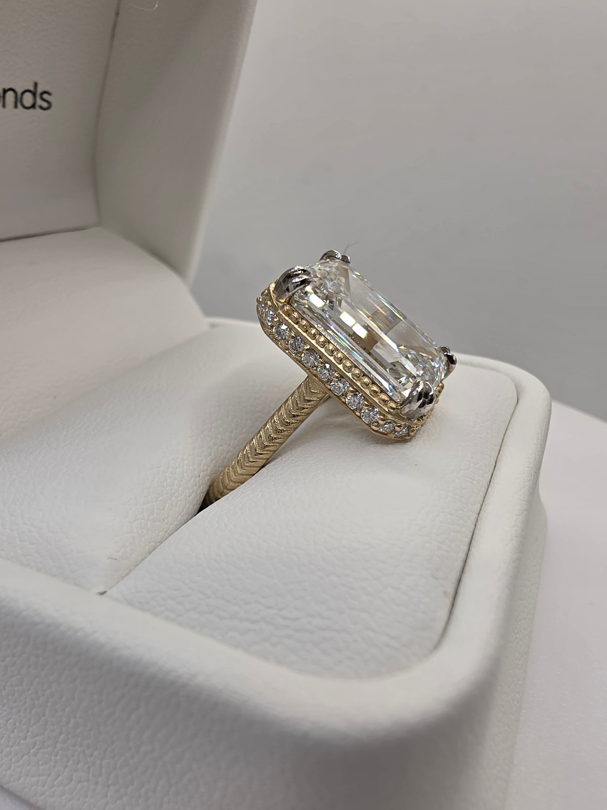 Emerald Diamond and yellow gold ring with millgrain detail in white ring box