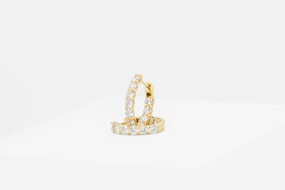 Yellow gold and diamond earrings on a plain backround