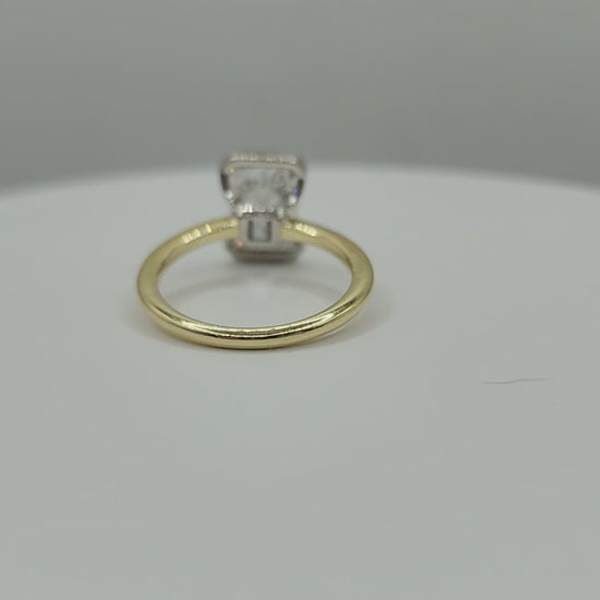 Gold ring spinning on a white display against a grey background