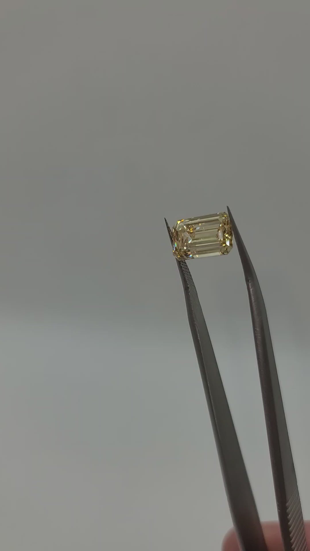 Video of yellow lab grown diamond held in tweezers