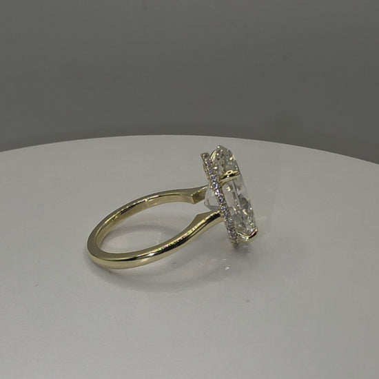 An oval diamond ring on a plain white background