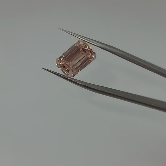 Pink lab diamond video held in tweezers
