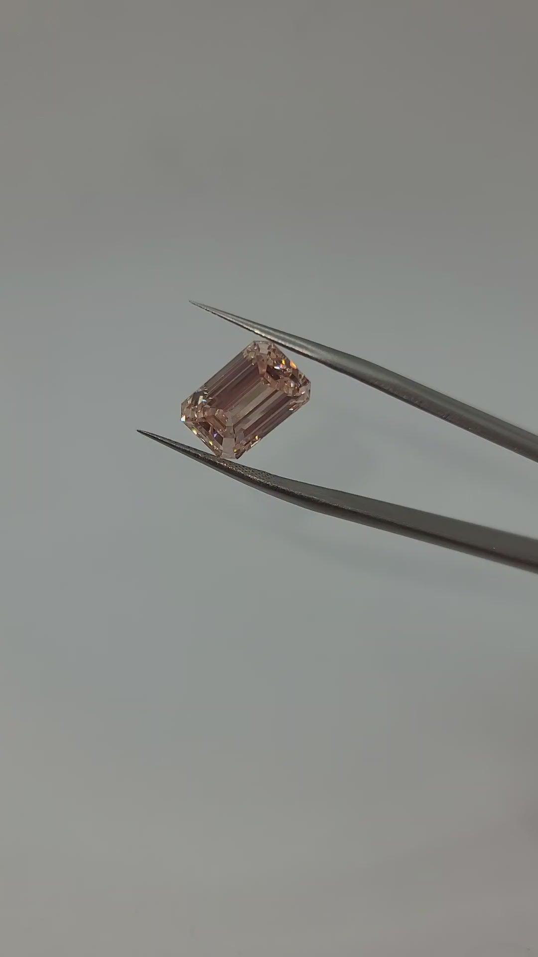 Pink lab diamond video held in tweezers