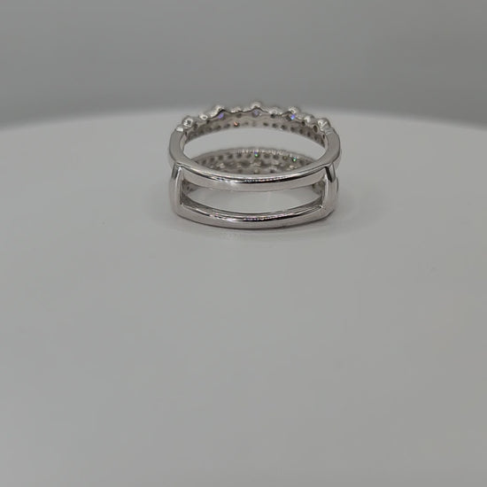 White Gold  ring with embedded stones on a white stand against a gray background