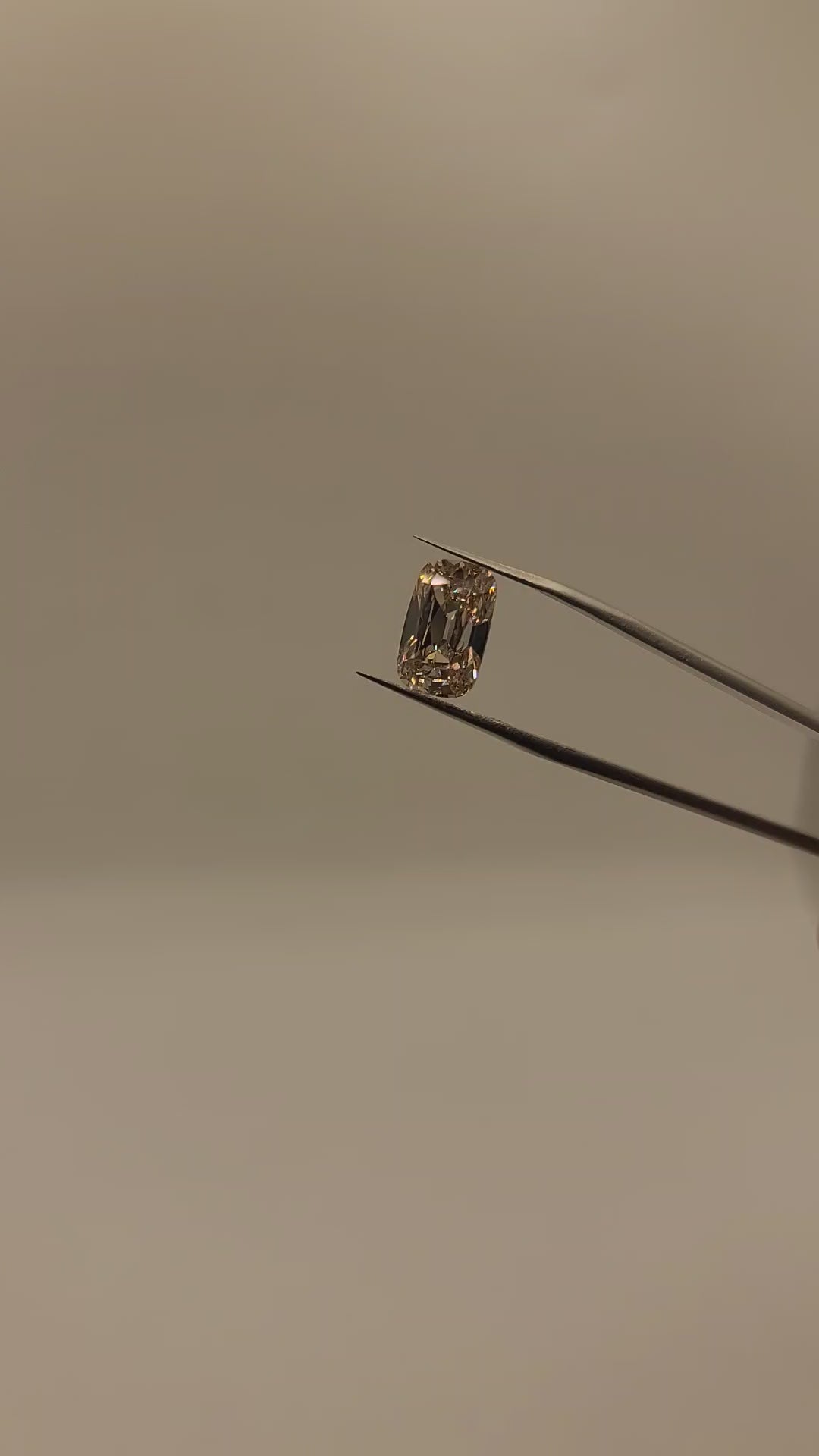 Video of lab diamond, brown tint, held in tweezers