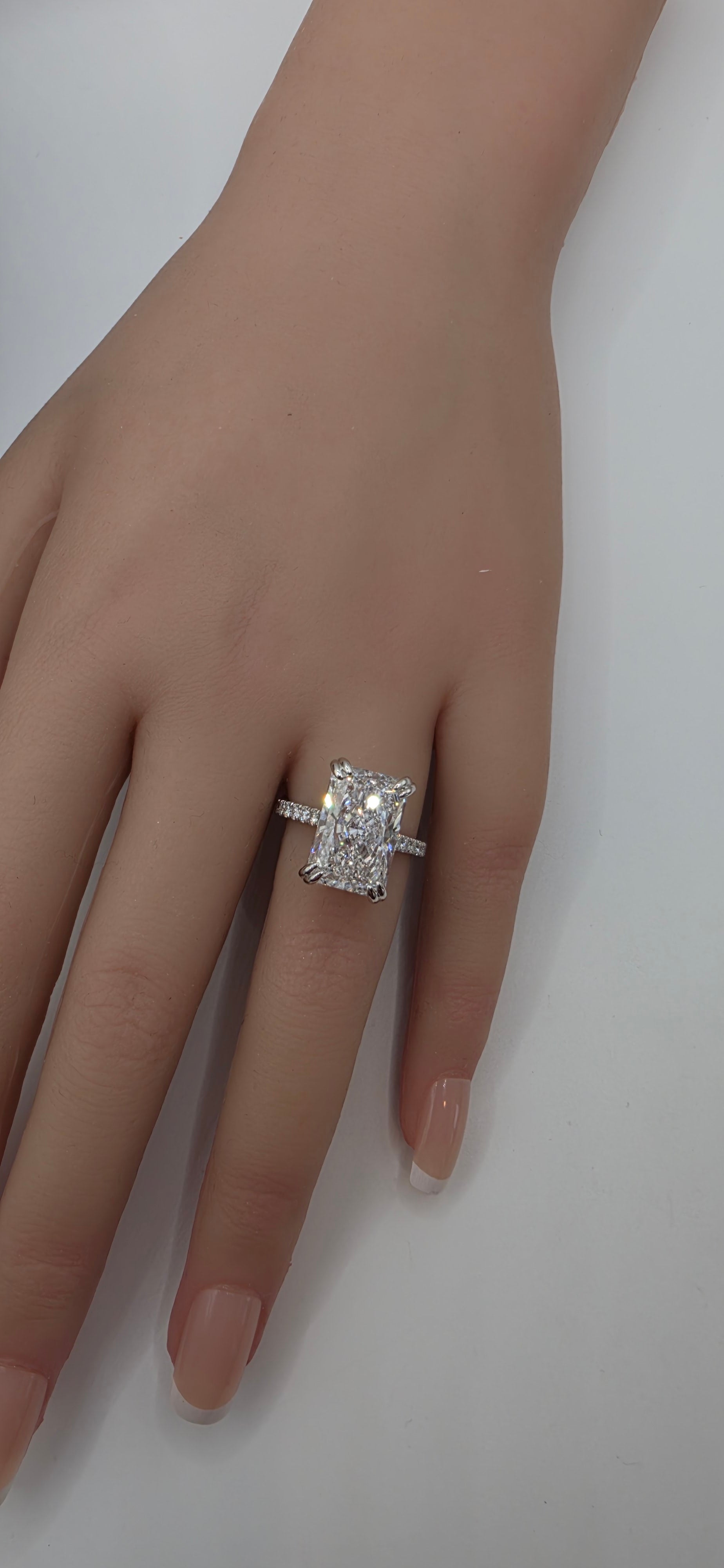 White Gold ring with a diamond on a hand against a white background