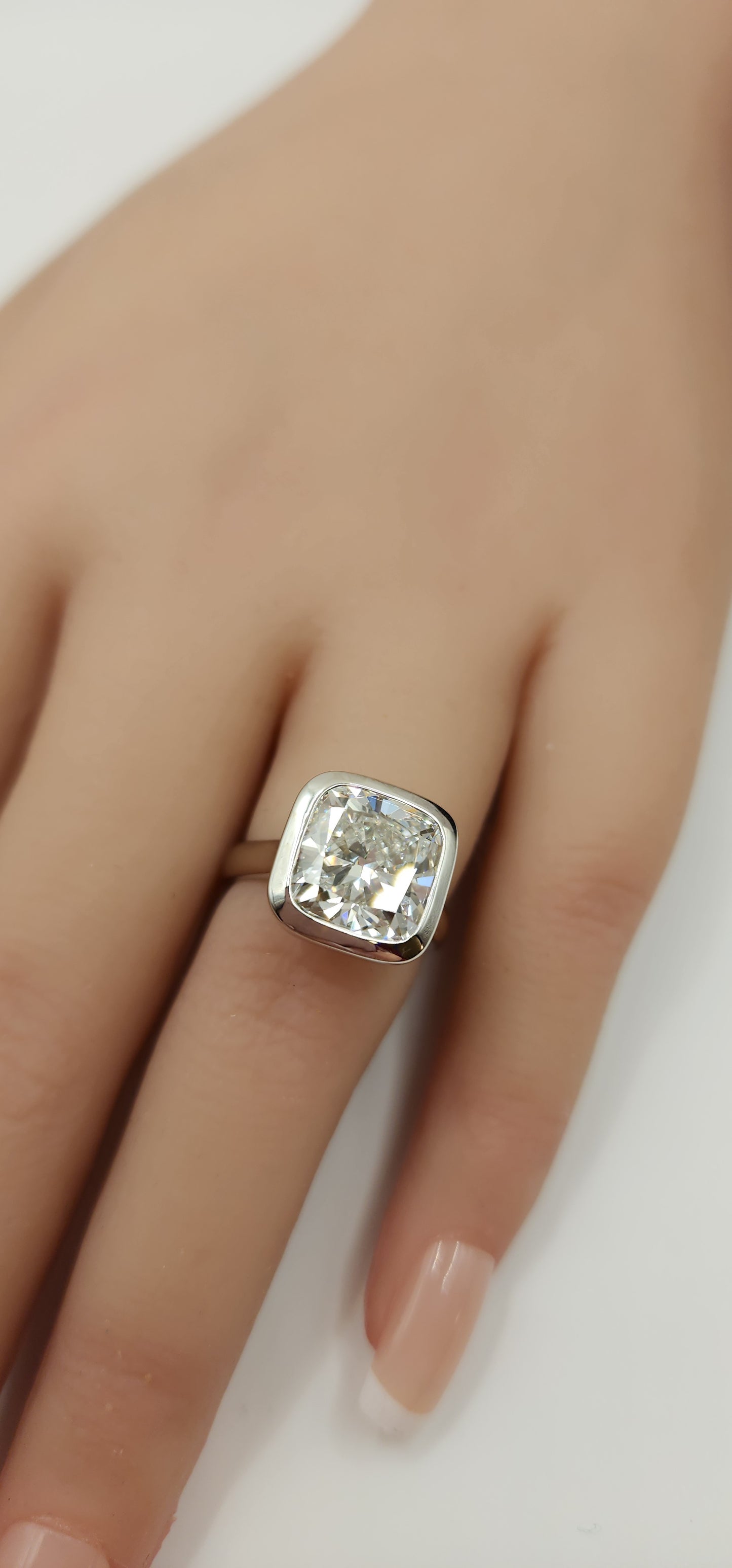 "The Brittney" is a 5.5 Carat Cushion Cut Lab Grown Diamond F/VS1, in a 14k White Gold Full Bezel, Cathedral Setting with Cross Cross Prongs