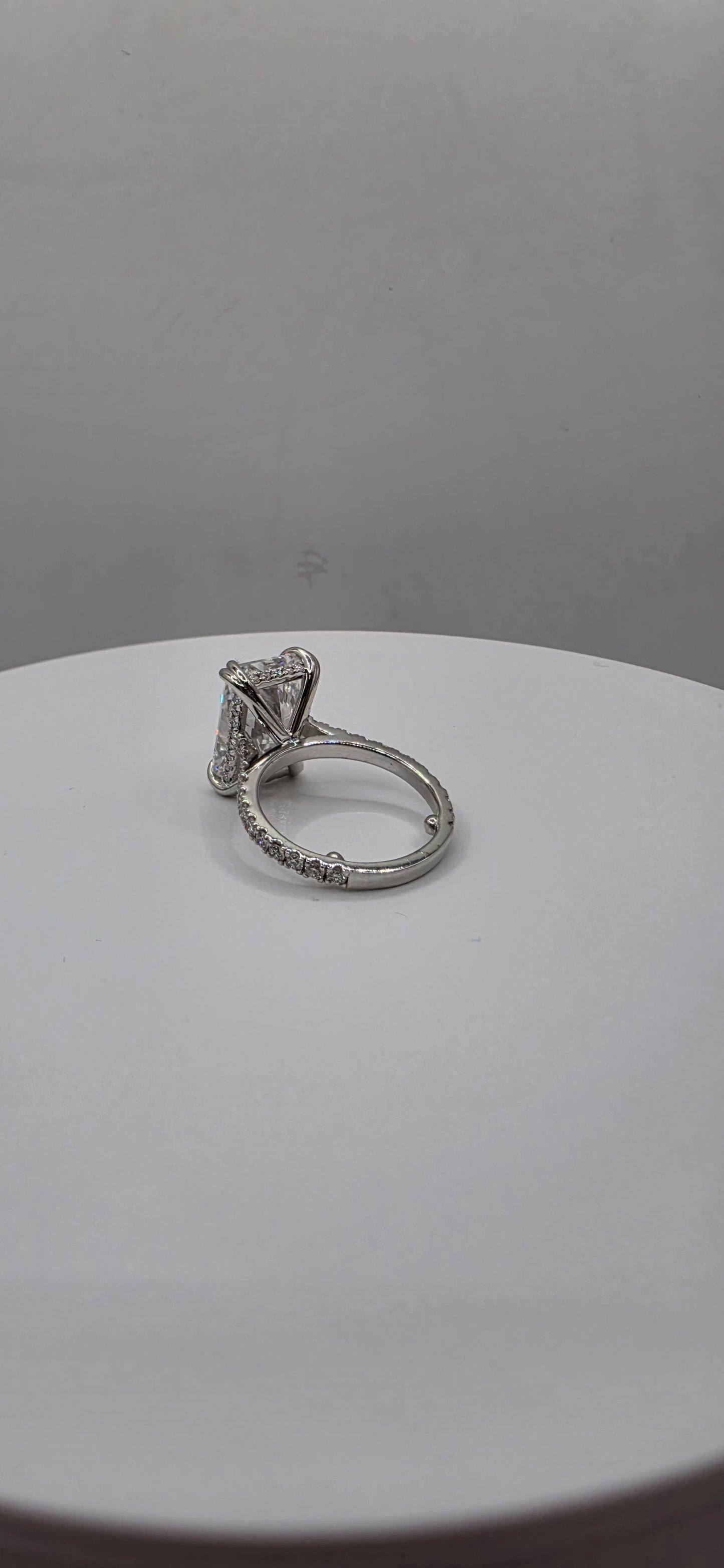 White gold ring on a white plate with a gray background